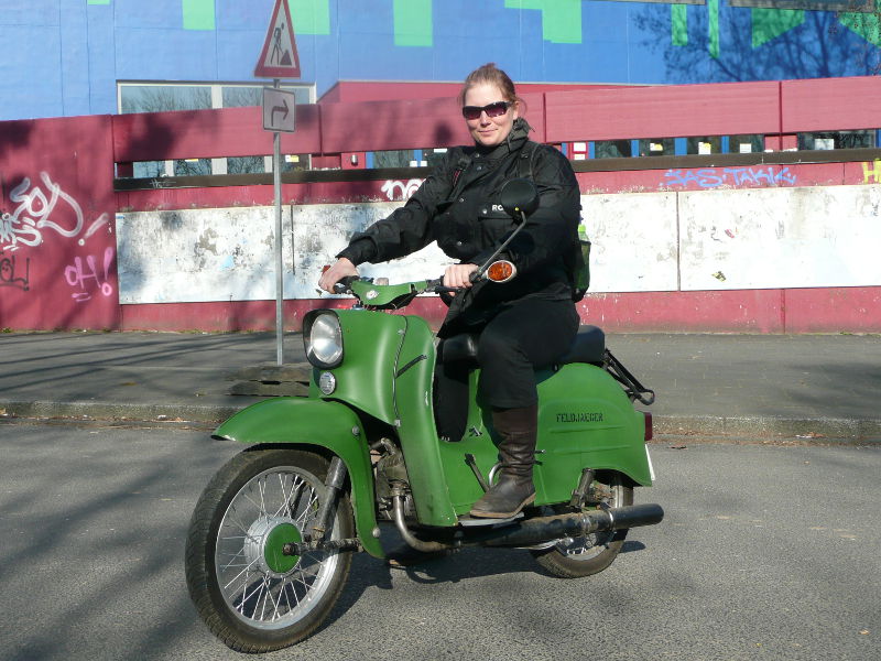 grünes Moped mit Frau