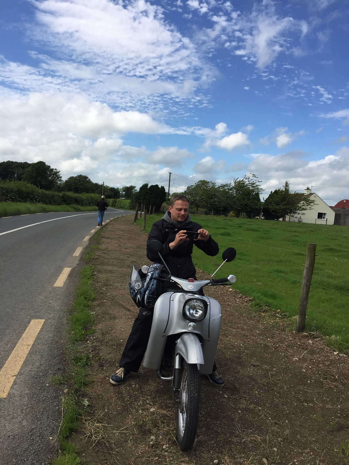 Mann auf Moped am Straßenrand