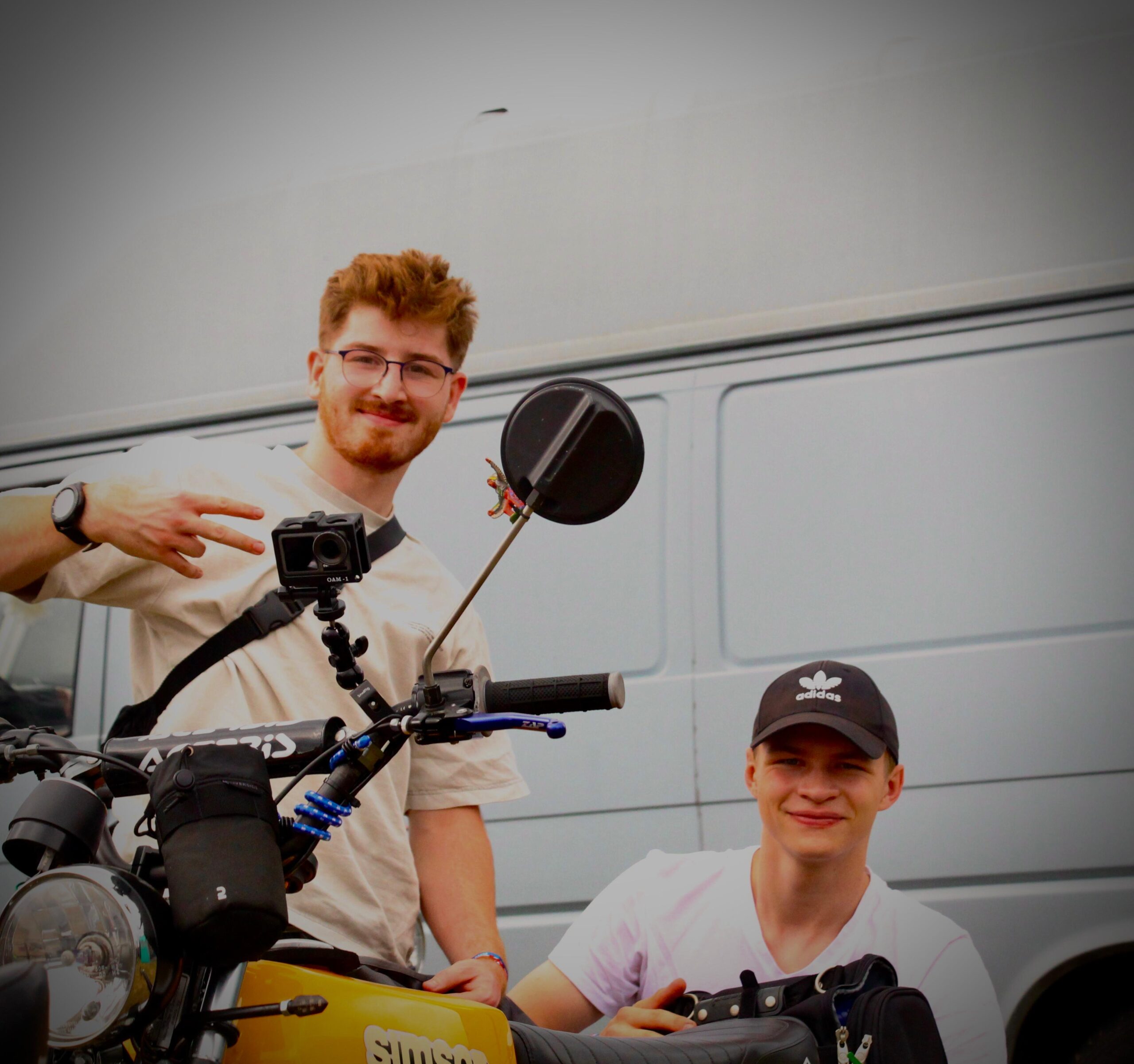 2 Junge Leute hinter einem Moped