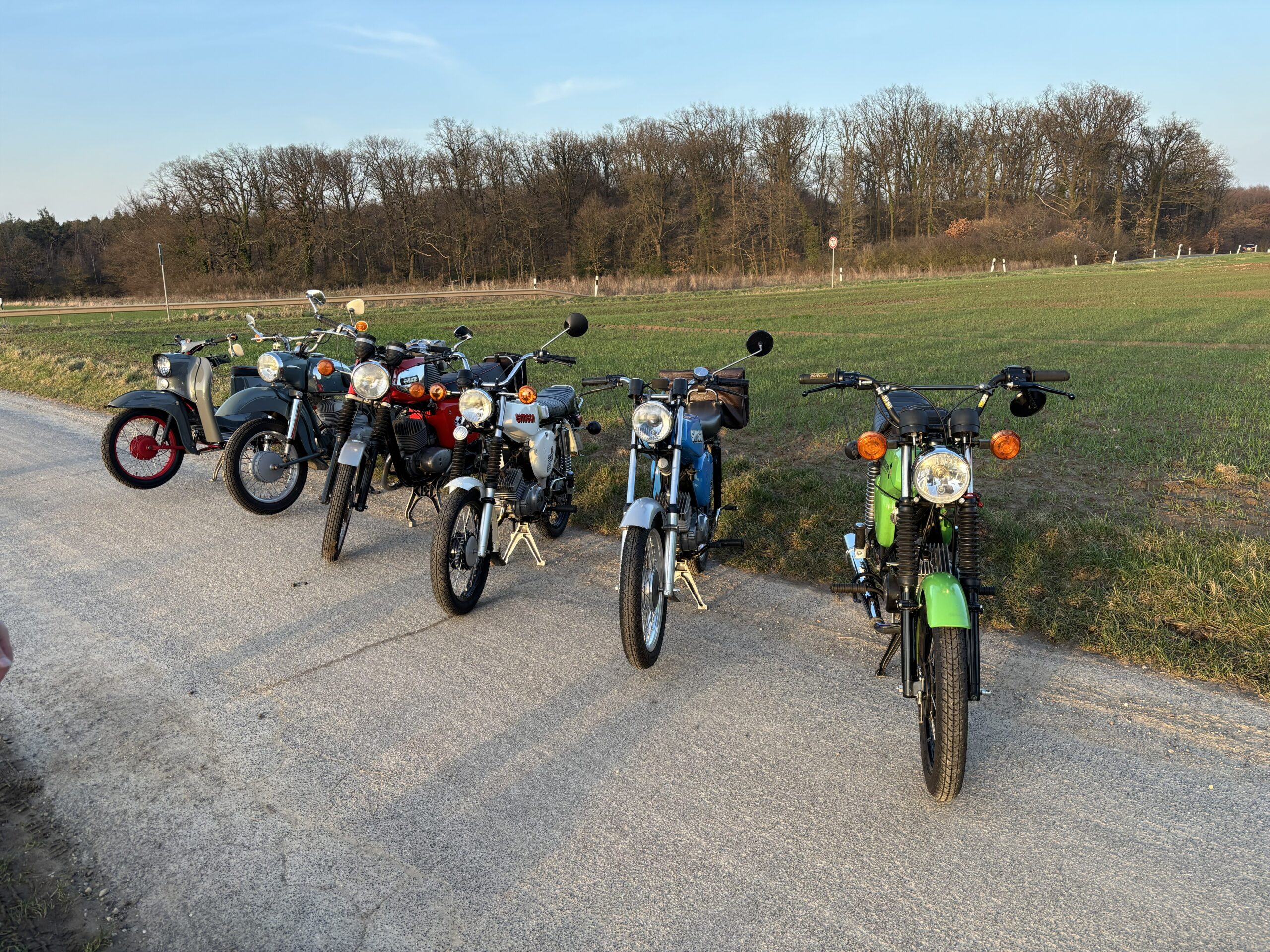 Mehrere Mopeds vor einem Feld